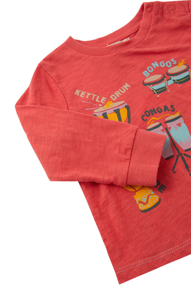 Close up of red long sleeve t-shirt with images of different types of drums.