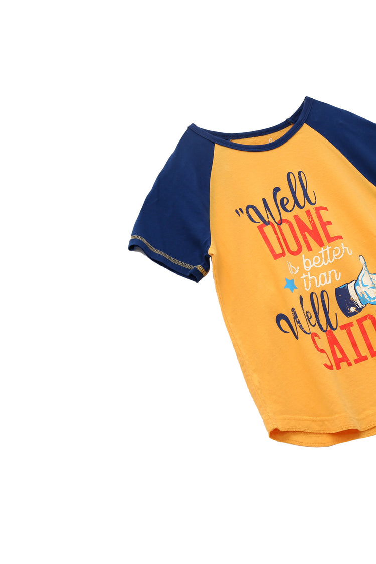 CLOSE UP OF YELLOW AND BLUE SHORT-SLEEVE RAGLAN TEE WITH A THUMBS UP GRAPHIC AND "WELL DONE IS BETTER THAN WELL SAID"