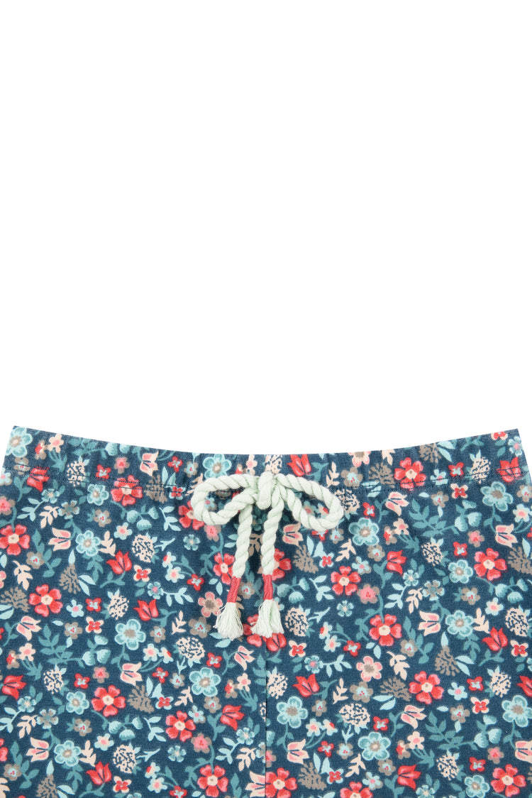 Close up of blue, white, pink and red floral print legging with tassels