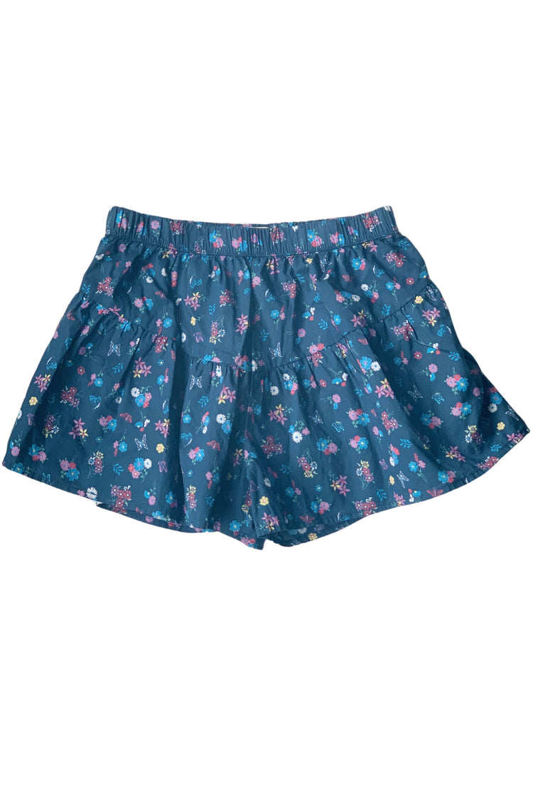 Back of blue elastic waist shorts with all over butterfly and flower pattern. 