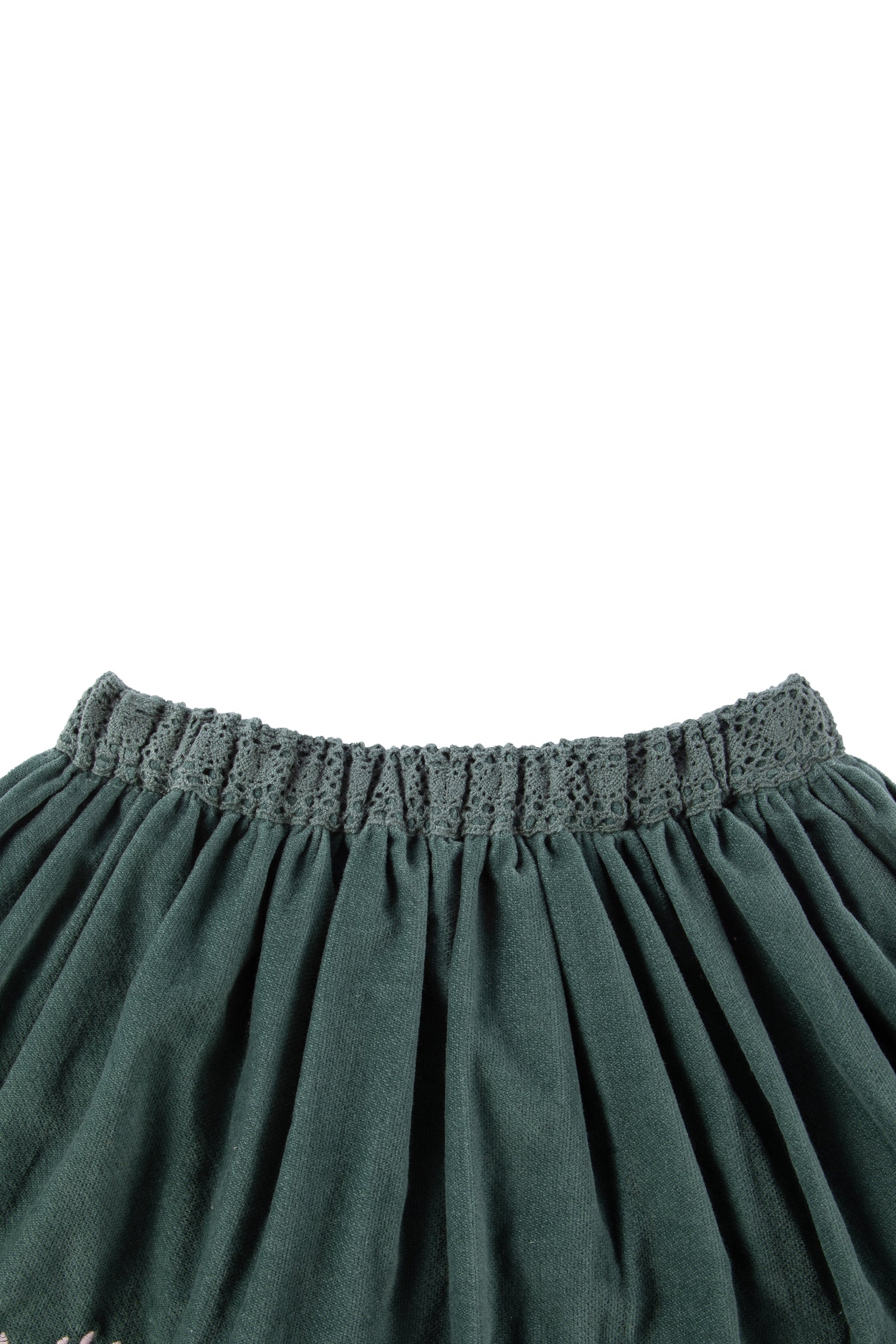 close up view of green velvet skirt with floral detail 