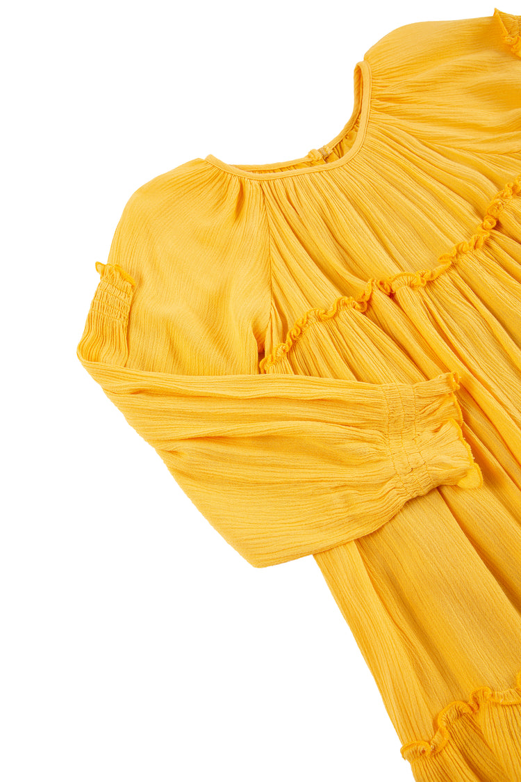 Close up side view of long sleeve yellow crinkle dress with smocking detailing