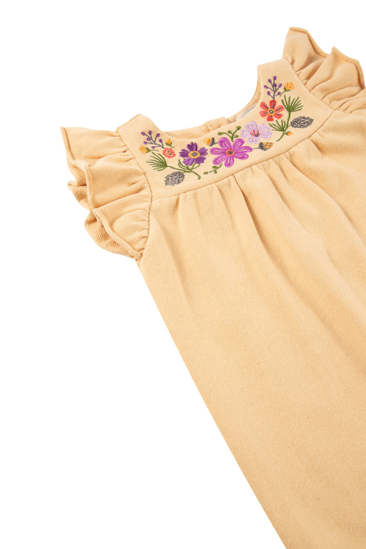 close up of yellow romper with knit flower pattern, illustrated porcupine & 'love the earth' text
