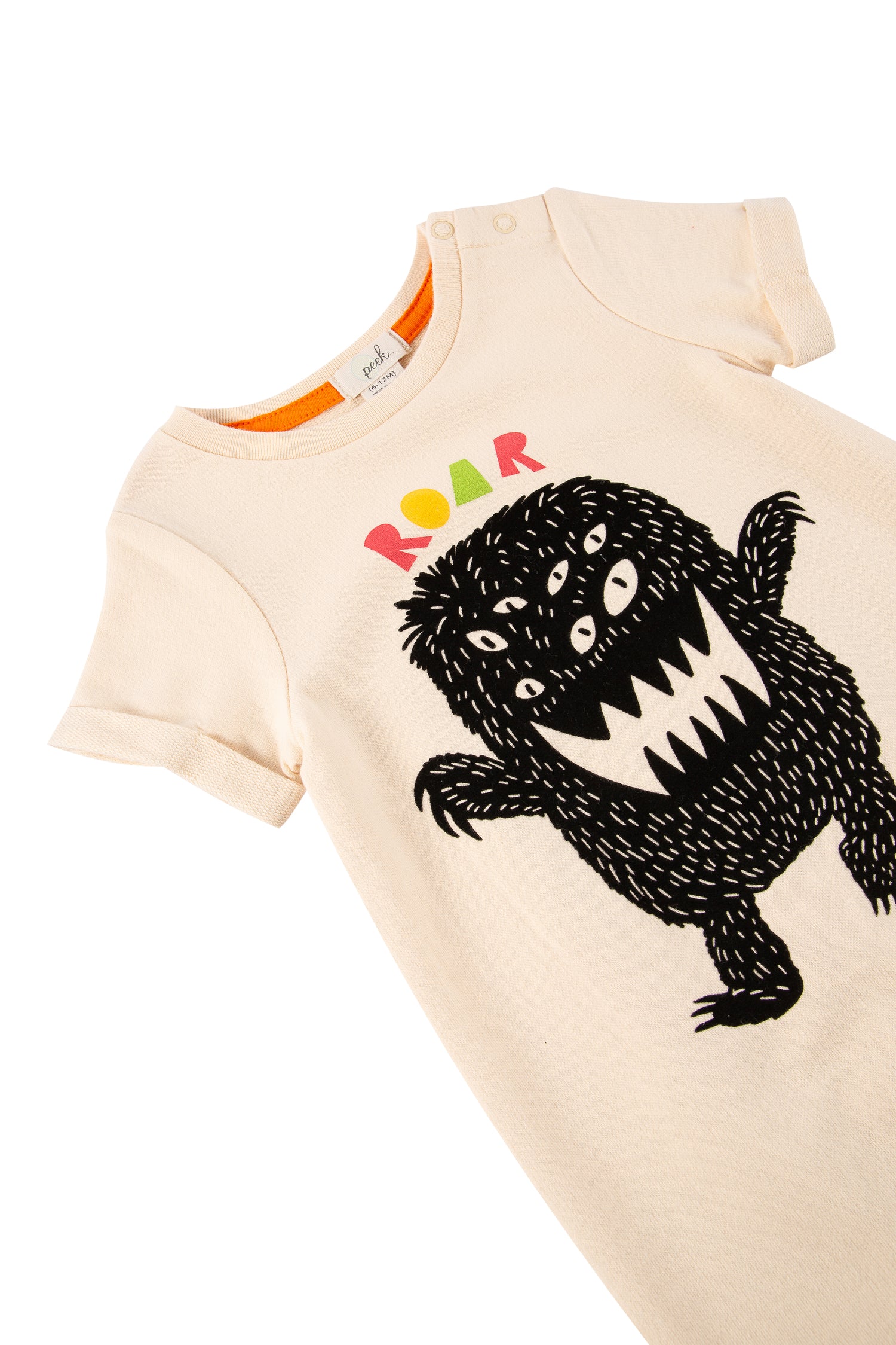 Close up of peach romper with monster illustration and text 'Roar'