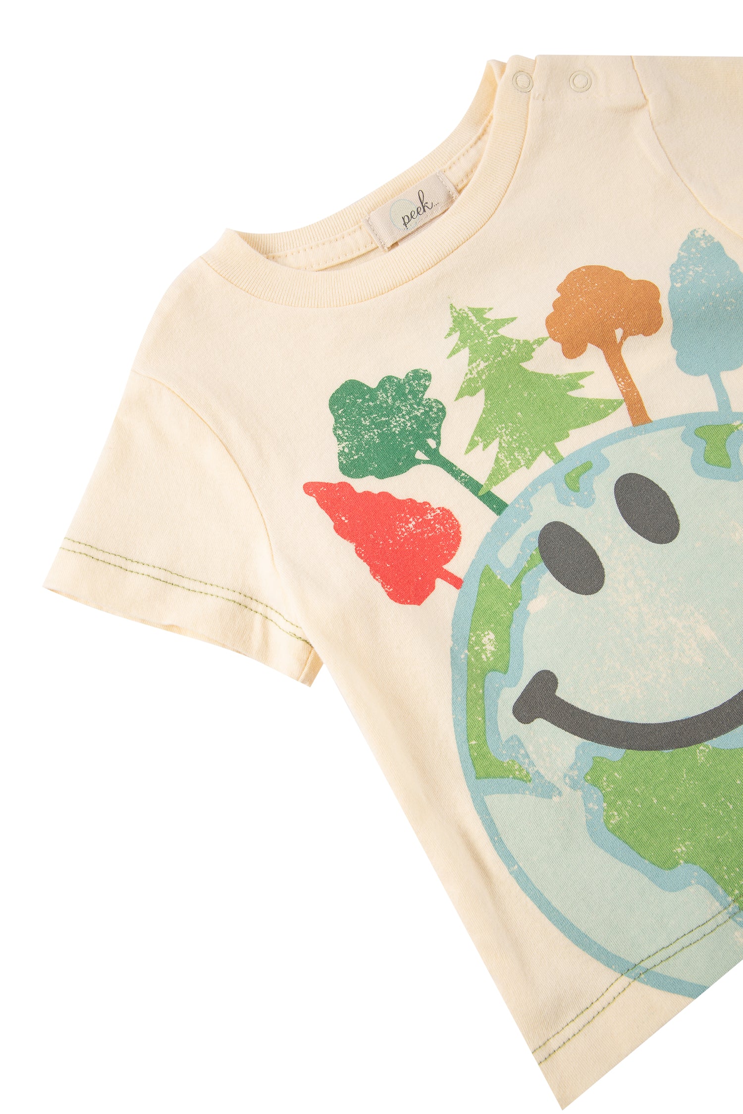 Close up of off-white t-shirt with multi-colored trees and globe with a smiley face