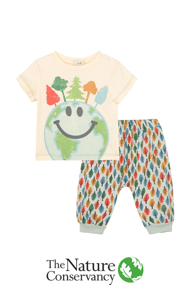 Off-white t-shirt with multi-colored trees and globe with a smiley face; gray sweatpants with multi-colored trees