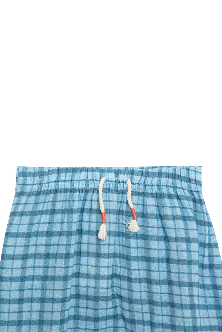 Close up view of blue plaid shorts with white pull strings