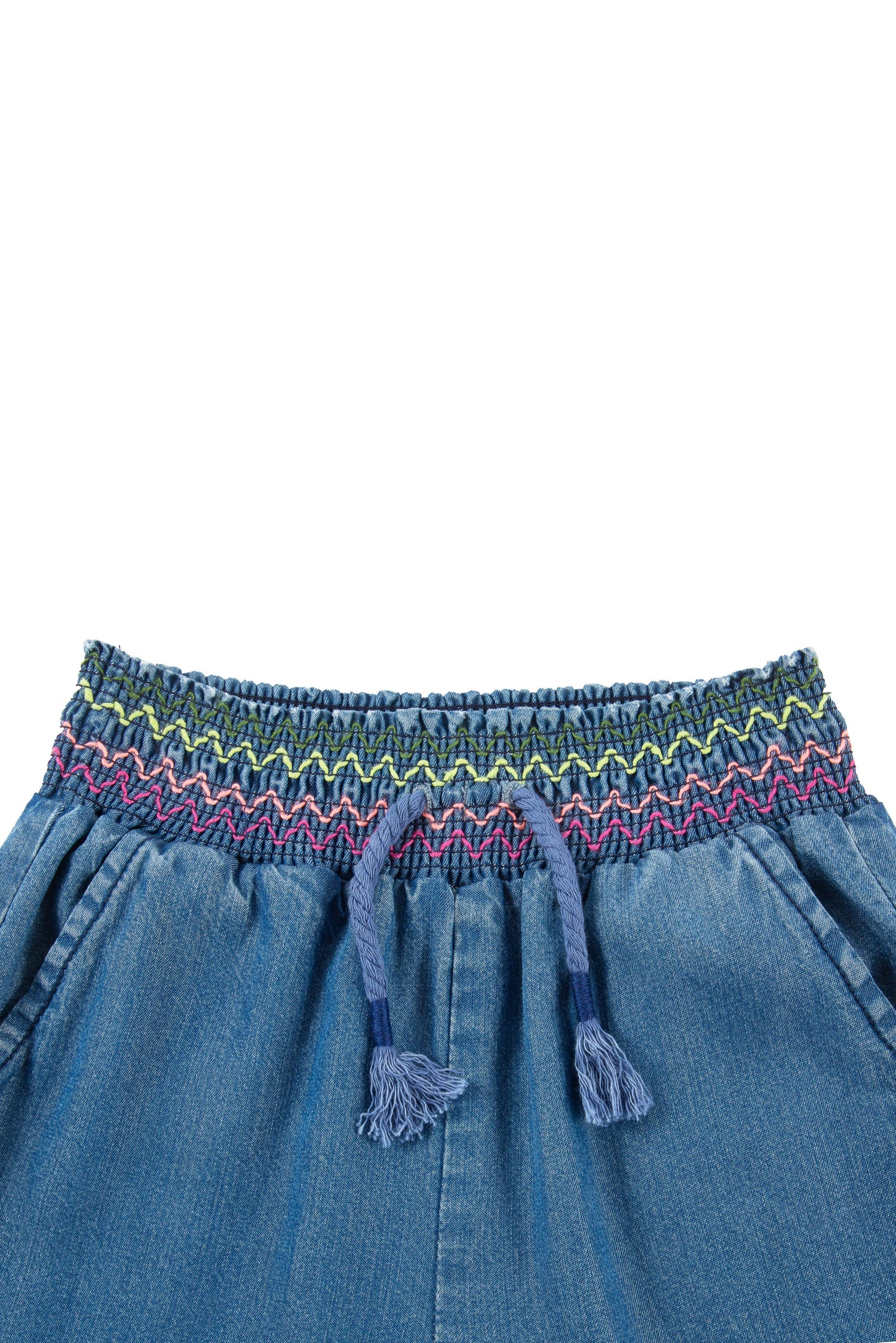 Close up of denim jogger with faux drawstring with fringe and multi-color, zig-zag stitching on elastic waist.